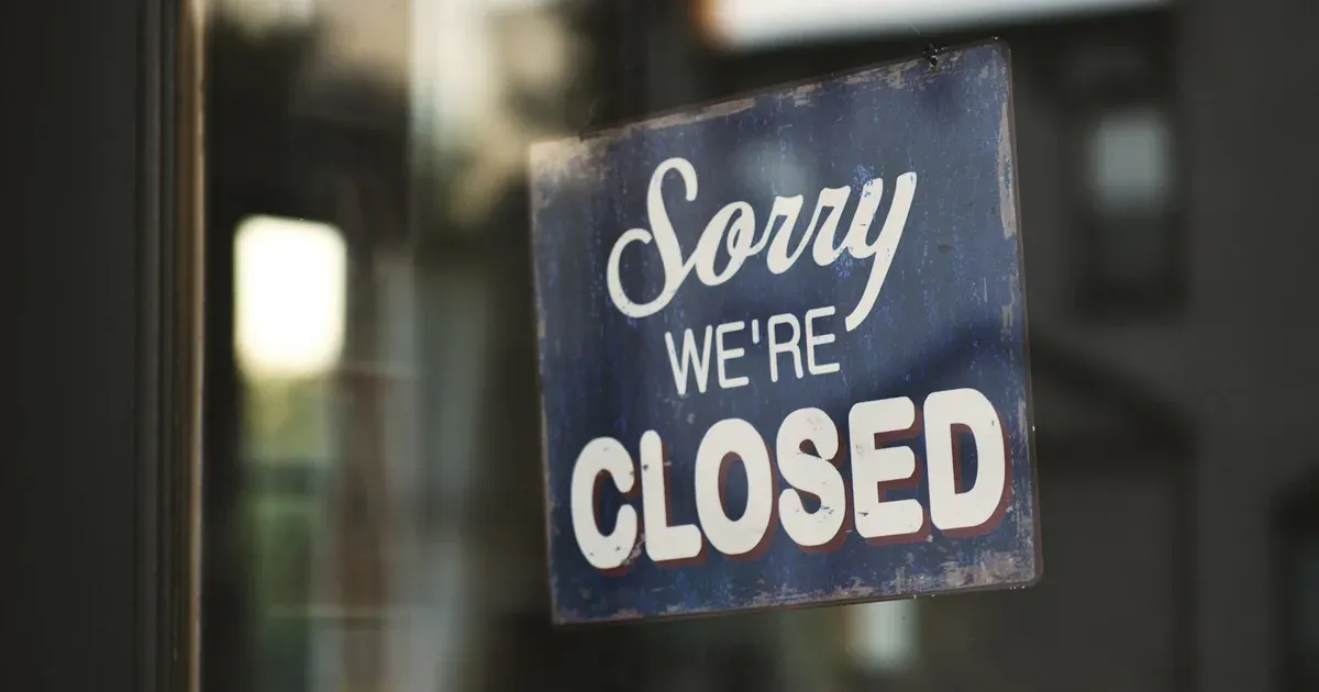 A vintage 'Sorry we're closed' sign hanging in a shop window, illustrating an article on South Africa's 2026 business liquidation statistics.